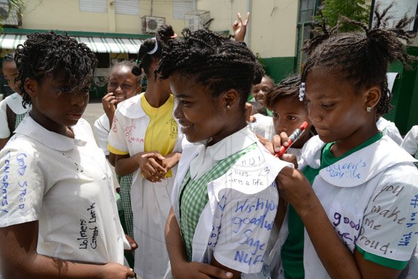 Jermaine Barnaby/Photographer
Students write farewell notes on fellow classmates at St Georges Girls school following the announcement of their Gsat results on Thursday June 18, 2015.