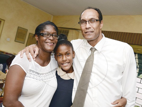 Jermaine Barnaby/Photographer<\n>Hannah Farr (center) with her parents Robert Farr (right) and mother Sonia Farr (left) following the GSAT performance which she scored full 100% in all subjects at the Vaz Preparatory school on Wednesday June 17, 2015. Farr will be attending Campion College.