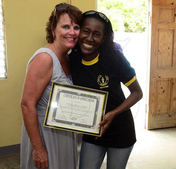 Gladstone Taylor / Photographer

Prof. Rebecca Lasher (Western Carolina University) accepts a certificate of appreciation from Francena Pryce (President for (United Mountain View Parents In Action) at the Hampstead Park Community center yesterday afternooon