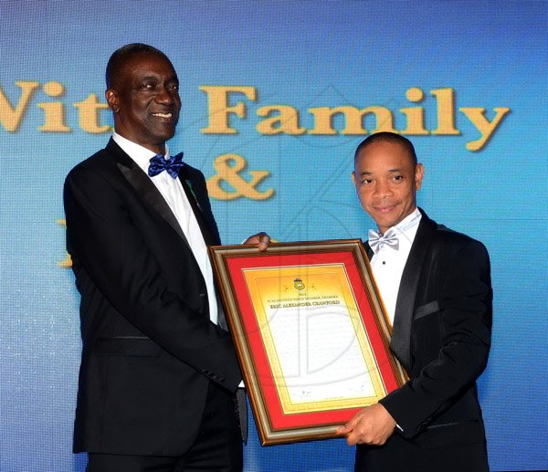 Winston Sill/Freelance Photographer
The Institute of Chartered Accountants of Jamaica (ICAJ) Annual Awards Banquet, for the presentation of ICAJ Distinguished MemberAward to Eric A. Crawford; and the Launch of 50th Anniversary Celebrations, held at the Jamaica Pegasus Hotelm New Kingston on Thursday night December 4, 2014.  Here Dennis Chung (right), President, ICAJ presents the citation to Crawford (left).