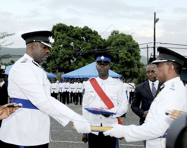 Winston Sill / Freelance Photographer
Island Special Constabulary Force (ISCF) Change of Command Parade for new Commandant James Golding, held at the ISCF Headquarters, Herman Barracks on Saturday October 6, 2012. Here outgoing Commandant Osmond Bromfield (right), hand the Baton to new Commandant Golding (left); at centre is Sgt, David Lowe.