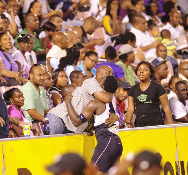 Ricardo Makyn/Staff Photographer
 Jamaica Colleges Javarn Gallimore is congratulated by JC Old Boy Norman Peart  after winning the  Boys open 400 Meters Hurdles Final   at the Boys and Girls Championships at the National Stadium on Friday 30.3.2012