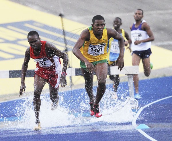 Ricardo Makyn/Staff Photographer
Left Nembhard Palmer  of Bellefield tries to catch up to Roshawn Johnson of St Jago High School  leading the field to win heat 2 of the Boys' Open 2000 Steeple Chase at the National Stadium at Boys and Girls Champs 2012