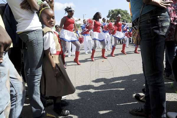 Ricardo Makyn/Staff Photographer
At left, the pint sized Shenise Campbell a 12-year-old student of Holy Trinity High School looks on as members of the Eagles Drum and Bugle Corp performing at the Jamaica Day activities at the Holy Trinity High School on Friday 17.2.2012