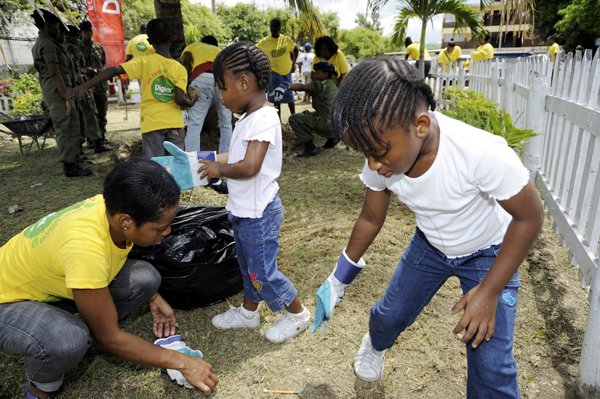 Ricardo Makyn/Staff Photographer
Left Shire Bailey Member of Staff from Digicel Jamaica with Kimoni and Kimberley Fltecher daughters of another member of staff working at the Companies Labour Day project at the Spanish Town Primary School on Monday 23.5.2011
