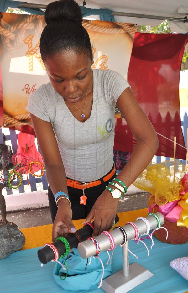 Jermaine Barnaby/Photographer
Annique Davis of Wolmers High school's Knot'z Enterprise makes adjustments to handcarft braclets on display during the Jampreneurs Expo & Summer Jam at the  Ranny Williams Entertainment Centre on  Saturday, July 5, 2014.