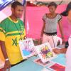 Jermaine Barnaby/Photographer
Peter Moses (right) Country manager for CitiBank Jamaica is caught up in the art work on display at the Excelsior High's Aspire Enterprise booth  during the Jampreneurs Expo & Summer Jam at the  Ranny Williams Entertainment Centre on  Saturday, July 5, 2014. At left is president Nizar Bisasor, at center is Elizabeth Lewin a memmber of the team.