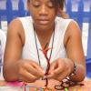 Jermaine Barnaby/Photographer
Georgia Bailey of the Ardenne High School in the process of handcrafting some braclets at the Eco-Pure booth during the Jampreneurs Expo & Summer Jam at the  Ranny Williams Entertainment Centre on  Saturday, July 5, 2014.