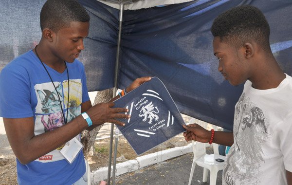 Jermaine Barnaby/Photographer
Ryan Henry (left) Vice president of the Creative Rulers at Jamaica College tries to sell one of the handkerchiefs done by students at his school to Brandon Treasure during the Jampreneurs Expo & Summer Jam at the  Ranny Williams Entertainment Centre on  Saturday, July 5, 2014.