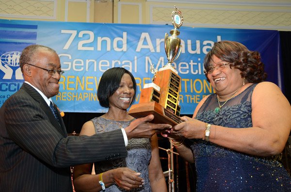 Rudolph Brown/Photographer
Johnathan Brown, President of the JCCUL presents the winner of the mega credit union trophy for 2013 to Jamaica Teachers' Association Co-operative Credit Union Limited's  Dr Dorothy Raymond, (right) and Barbara Gascoigne at the JCCUL 72nd anniversary Dinner and awards Banquet at the Ritz Carlton on Saturday, May 17, 2013