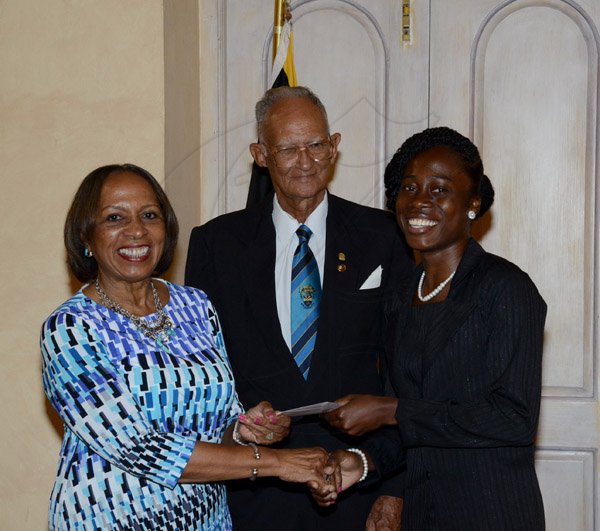 Winston Sill/Freelance Photographer
The Jamaica Institute of Management (JIM) Limited presents the JIM  2013 Manager of the Year Award Ceremony, held at King's House on Thursday evening May 29, 2014. Here Janette Phillip (left) presents the George Phillip Scholarship to Ranae Reid (right); looking-on at centre is Dr. Alfred Sangster.