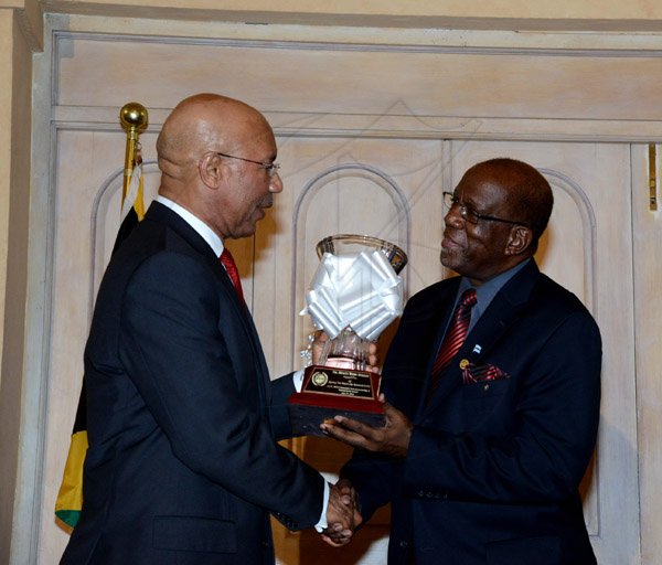 Winston Sill/Freelance Photographer
The Jamaica Institute of Management (JIM) Limited presents the JIM  2013 Manager of the Year Award Ceremony, held at King's House on Thursday evening May 29, 2014. Here Governor General Sir Patrick Allen (left) presents the Entrepreneurship and Community Development Award to Dr. Henley Morgan (right), of Agency for Inner-city Renewal.