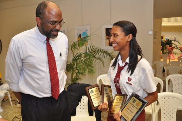 Jermaine Barnaby/Photographer
Earl Jarrett (left) General Manager of Jamaica National Building Society (JNBS) shares some insights about photography with Jodi Morgan of Glenmuir High who was announced the top JN Foundation Resolution Project Awardee during an awards Ceremony at the Olympia Gallery- 202 Old Hope Road on Tuesday, July 15, 2014.