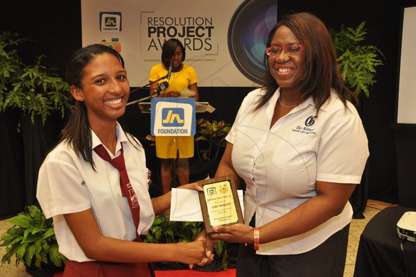 Jermaine Barnaby/Photographer
Terry-Ann Wilson (right) Assistant Manager, Business Development and Marketing The Gleaner Company hands over the Emerging Photo Advocate award to Jodi Morgan at the JN Foundation Resolution Project Awards Ceremony at the Olympia Gallery- 202 Old Hope Road on Tuesday, July 15, 2014.