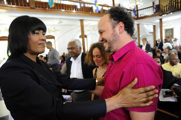 Rudolph Brown/Photographer
Portia Simpson-Miller greets Matthew Maxwell at the funeral sevice of John Maxwell at UWI Chapel on Monday, December 20-2010