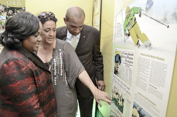 Rudolph Brown/Photographer
Curator Susanne Fredricks (centre) makes a point to Minister without portfolio in the Office of the Prime Minister with responsibility for sports Natalie Neita-Headley (left) and Lissant Mitchell, CEO Scotia Investment Jamaica Limited during the launch of the 'Journey of Champions: 50 Years of Jamaican Athletic Excellence' archival exhibition at the St Catherine Parish Library yesterday.