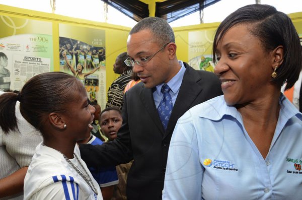 Rudolph Brown/Photographer
The Gleaner's Managing Director Christopher Barnes (centre) shares a light moment with national junior sprint hurdler Megan Simmonds (left) and Carlene Edwards, Senior Corporate Communications Officer of Supreme Ventures Limited during the launch of the 'Journey of Champions: 50 Years of Jamaican Athletic Excellence' archival exhibition at the St Catherine Parish Library yesterday.