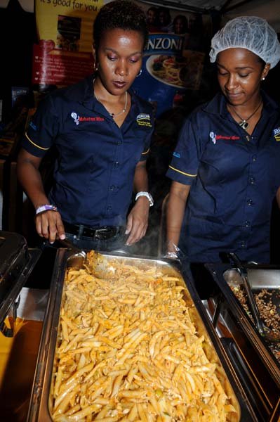 Winston Sill/Freelance Photographer
Product Manager Georgia Balfour (left) sorts the Ronzoni Penne Pasta with Chicken as Yolanda Garvey looks on attentively
Kgn. Kitchen Night Market, held at Hope Gardens, Old Hope Road on Saturday night August 24, 2013.