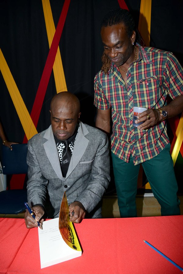 Winston Sill/Freelance Photographer
Launch of Isaiah Laing Book, held at Police Officers Club, Hope Road on Wednesday night January 15, 2014. Here Laing signs a copy of his book for Fashion designer Bill Edwards (right).