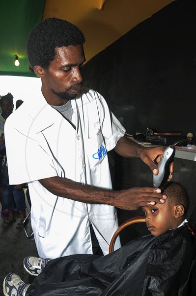 GladstoneTaylor Photographer
Barber Marlon Edwards  Student of Heart Trust NTA cuts the Hiar Donovan Carr at the Lime Skool Aid at Jam World Portmore St Catherine