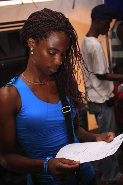 Anthony Minott/Freelance Photographer
Yannique Ewers, reads a registration form, as she awaits a medical check up during a LIME Skool Aid back-to-school project at Jam World, Portmore, St Catherine on Saturday, September 1, 2012.