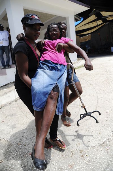 Ricardo Makyn/Staff Photographer
Nelleta Thompson is being carried from the Polling Station in Lindo's Gap East Rural St Andrew by Kadian Smith and Tanesha Taylor on Election Day