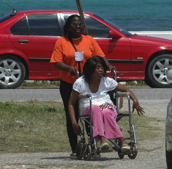 Photo by Adrian Frater

A PNP work assist a physically challenge woman as she makes her way to vote in Hanover yesterday.