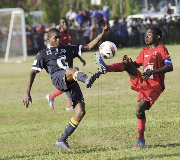 Ricardo Makyn/Staff Photographer
 Jamaica College's Kevin Blackwood and Camperdown High Schools' Romario Ward vie for the Ball  in their Manning Cup encounter at Bellevue on Friday 14.9.2012
