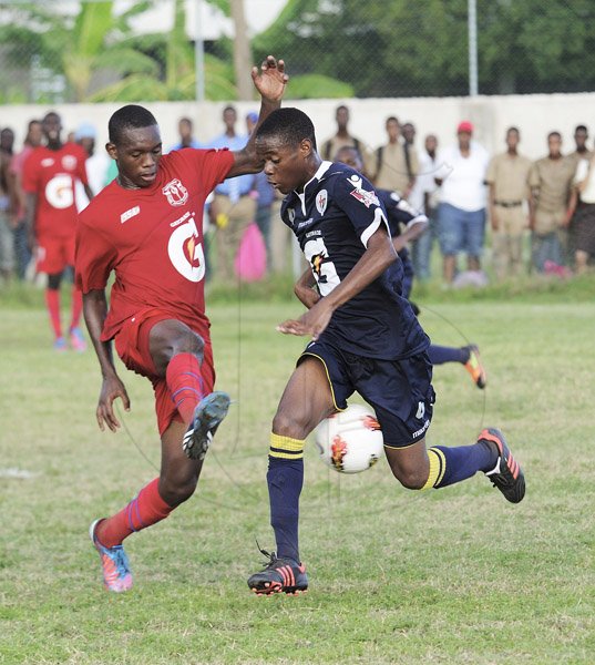Ricardo Makyn/Staff Photographer
Left Camperdown High Schools' Hakeem Smith attempts to stop Jamaica College's Steffan Logan in their Manning Cup encounter at Bellevue on Friday 14.9.2012