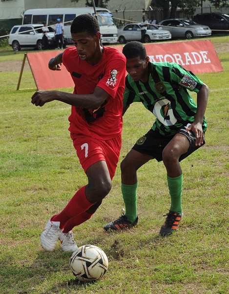 Ian Allen/Photographer Calabar Gequan Pringle (left) and Bridgeport Rayon Swire tussle for possession during their ISSA/Gatorade/Digicel Manning Cup clash at Red Hills Road yesterday. The match ended 1-1.