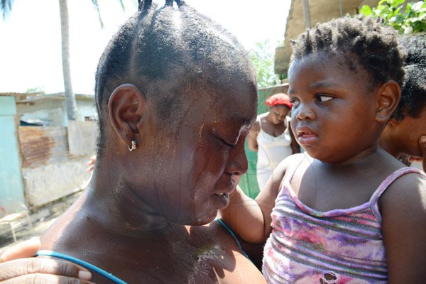 Rudolph Brown/PhotographerFamily members mourning the death of family after gunmen shoot up seven killing five including three children and set their home ablaze at Africa settlement in March Pen Community in Spanish Town on Sunday, October 9