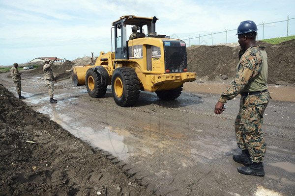 Rudolph Brown/Photographer
JDF Soldiers use a bulldozer to remove a pile up of sand and silt from the palisadoes main road in Kingston from High tides and high winds, related to Hurricane Matthew on Tuesday, October 4, 2016