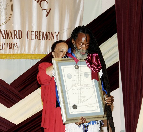 Winston Sill/Freelance Photographer
earl 'Chinna' Smith looks at his citation as Barbara Gloudon fits his Silver Musgrave Medal during the Institute of Jamaica's Musgrave Medal Award Ceremony at the institute's complex yesterday.






The Institute of Jamaica (IOJ) presents the Musgrave Medals Award Ceremony, held at The Institute's Complex, East Street, Kingston on Wednesday October 16, 2013. Here are Barbara Gloudon (left), Fellow, IOJ; and Earl "Chinna" Smith (right), Siolver Awardee.