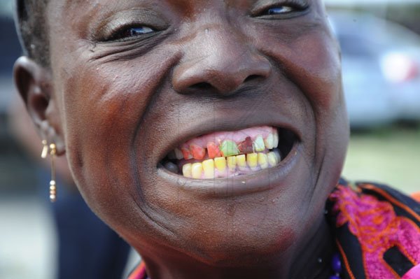 Ricardo Makyn/Staff Photographer
Election Day
This Woman show's off Her Teeth  are Coloured in Orange and Green in Springfield in  the Western St Thomas Constituency.
