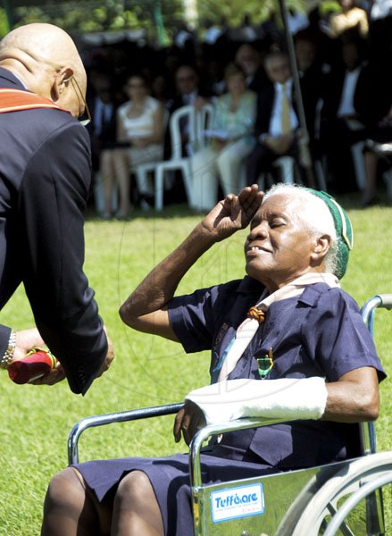 Ricardo Makyn/Staff Photographer.
Myrtle Clarke salutes Governor General Sir Patrick Allen as she is awarded the Badge of Honour for Long and Faithful Service for over 50 years of service to the Scouts Association of Jamaica. Clarke was one of 98 people who received honours during the investiture and presentation of National Awards at Kings House, St Andrew. SEE STORY ON A2