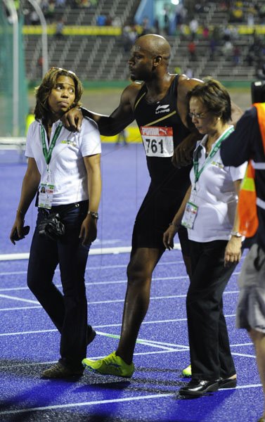 Ricardo Makyn/Staff Photographeer
Asafa Powell being attended too by Medical Staff after finishing third in the Mens 100 Meter Final   at the Supreme Ventures JAAA National Senior Championship at the National Stadium  on Friday 29.6.2012