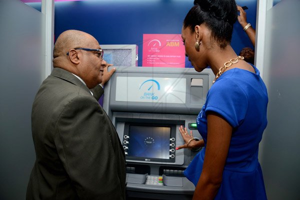 Winston Sill/Freelance Photographer
BUSINESS DESK:----- National Commercial Bank (NCB) official launch  of it's Bank of the future project, "Bank On The Go", held at the New Kingston Branch, Knutsford Boulevard  on Thursday night January 16, 2014. Here are Major Richard Reece (left); and Anneka Bynes-Thompson (right), NCB, May Pen Branch.