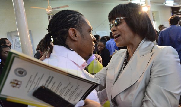 Rudolph Brown/Photographer
Prime Minister Portia Simpson Miller greets Yohan Blake at the service of thanksgiving for the 140th Anniversary of the City of Kingston and The Achievements of the London 2012 Olympians and Paralympians " Repairing the Breach, Restoring the Treasure" at the East Queen Street Baptist Church on East Queen Street in Kingston on Sunday, October 14, 2012