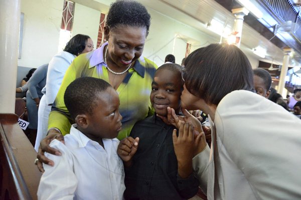 Rudolph Brown/Photographer
Prime Minister Portia Simpson Miller kissed Tiran Mascwell while Olivia Grange, Ajani Harrison looks on at the service of thanksgiving for the 140th Anniversary of the City of Kingston and The Achievements of the London 2012 Olympians and Paralympians " Repairing the Breach, Restoring the Treasure" at the East Queen Street Baptist Church on East Queen Street in Kingston on Sunday, October 14, 2012