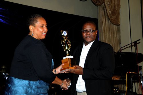 Winston Sill / Freelance Photographer
The Gleaner's Opinion Editor Andre Wright collects the best cover design award in the newspaper category on behalf of his colleague Shaunette Wright from Greta Bogues, general manager for the corporate affairs division at Wray & Nephew at the Press Association of Jamaica's national awards banquet at the Jamaica Pegasus Hotel in St Andrew on Friday.