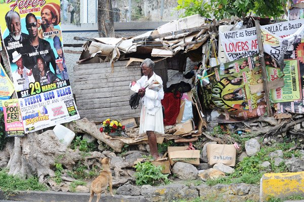 A woman outside a shack on Windsor road St Ann's bay during a tour of parish capital, St Ann's Bay on Saturday March 21, 2014.
