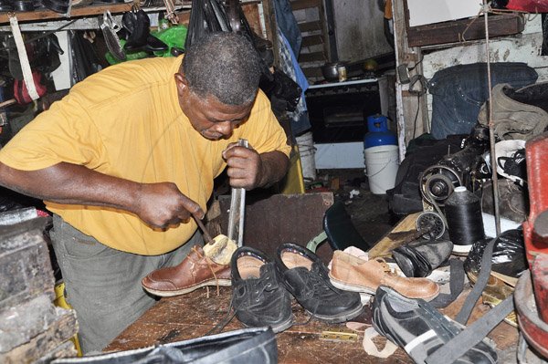 Jermaine Barnaby/Photographer
Shoemaker repair man Caliper inside his Donald Duck's shoe shop along Main Street during tour of parish capital, St Ann's Bay on Saturday March 21, 2014.