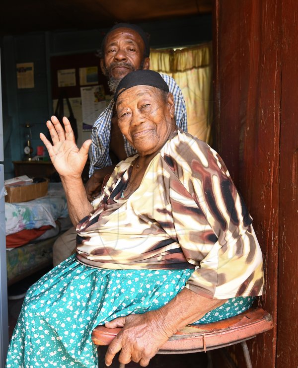 Noel O'Connor care giver with 98 year old Ina Ranklin of Old Road  who's kitchen was being rebuilt by the efforts of personnel from the Guanaboa Vale Police Station  in cooperation with residents and a few donors in the Kitson Town community, St Catherine.
