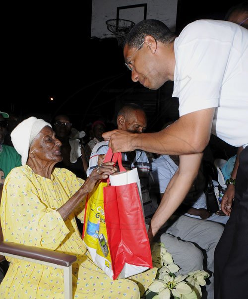 JIS/Photograph                                                                                                                                                                        Pics from PM?s Treats                                                                                                                                                             Prime Minister Andrew Holness presents a special gift to 100-year-old Gladys Mae Murray, who was among hundreds of guests at his treat for golden agers from his West Central St. Andrew constituency at the Olympic Gardens community centre, Olympic Way on Saturday, December 24.