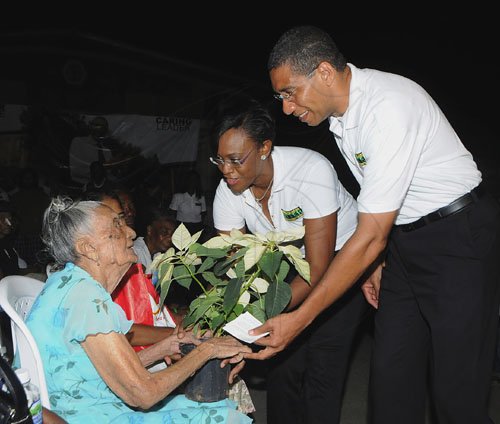 JIS/Photograph                                                                                                                                                                        Pics from PM?s Treats                                                                                                                                                             Prime Minister Andrew Holness and his wife, Juliette, presenting a basket of flowers to 101-year-old Olive Williams, the oldest constituent attending his treat for the elderly at the Olympic Gardens community centre, Olympic Way on Saturday, December 24.