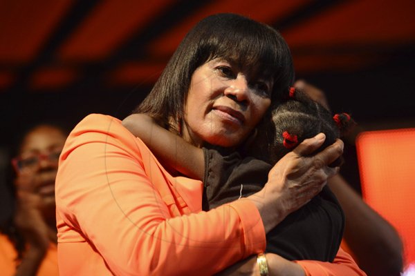 Rudolph Brown/Photographer
Prime Minister Portia Simpson Miller hugs a little girl after giving her speaks at the PNP's 74th Annual Conference 2012 at National Arena in Kingston on Sunday, September 16-2012
