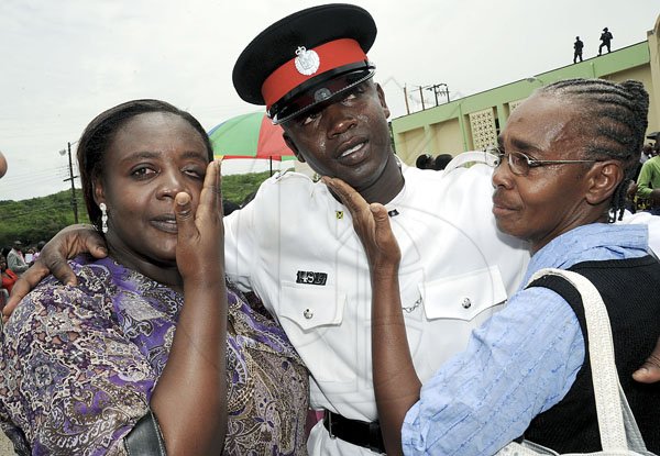 Norman Grindley/Chief Photographer
Delroy McIntosh, (centre) came to tears with his sister Judith, (left) and mother Sonia Haye at the end of his graduation yesterday. McIntosh was one of the one hundred and ninety seven constables that graduated from the Jamaica police academy in Twickenham park St. Catherine yesterday.