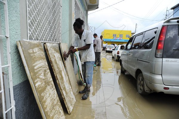 Ricardo Makyn/Staff Photographer
Business owners and workers doing clean up operations after flooding in   Port Maria St Mary
