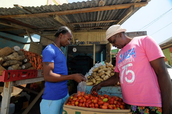 Gladstone Taylor / Photographer

Marvin Bailey (Vegetable Vendor), Sells tomatoes to Lyn Beckford from his shop located on the  port maria main road 

Parish capital feature on Port Maria.