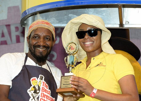 Rudolph Brown/Photographer
Nikolette Williams, branch promotions officer of Best Dressed presents the winning trophy to Malik Martin of Royal Maroon at the Best Dressed Chicken Portland Jerk Festival at Folly Ruins in Portland on Sunday, July 7, 2013